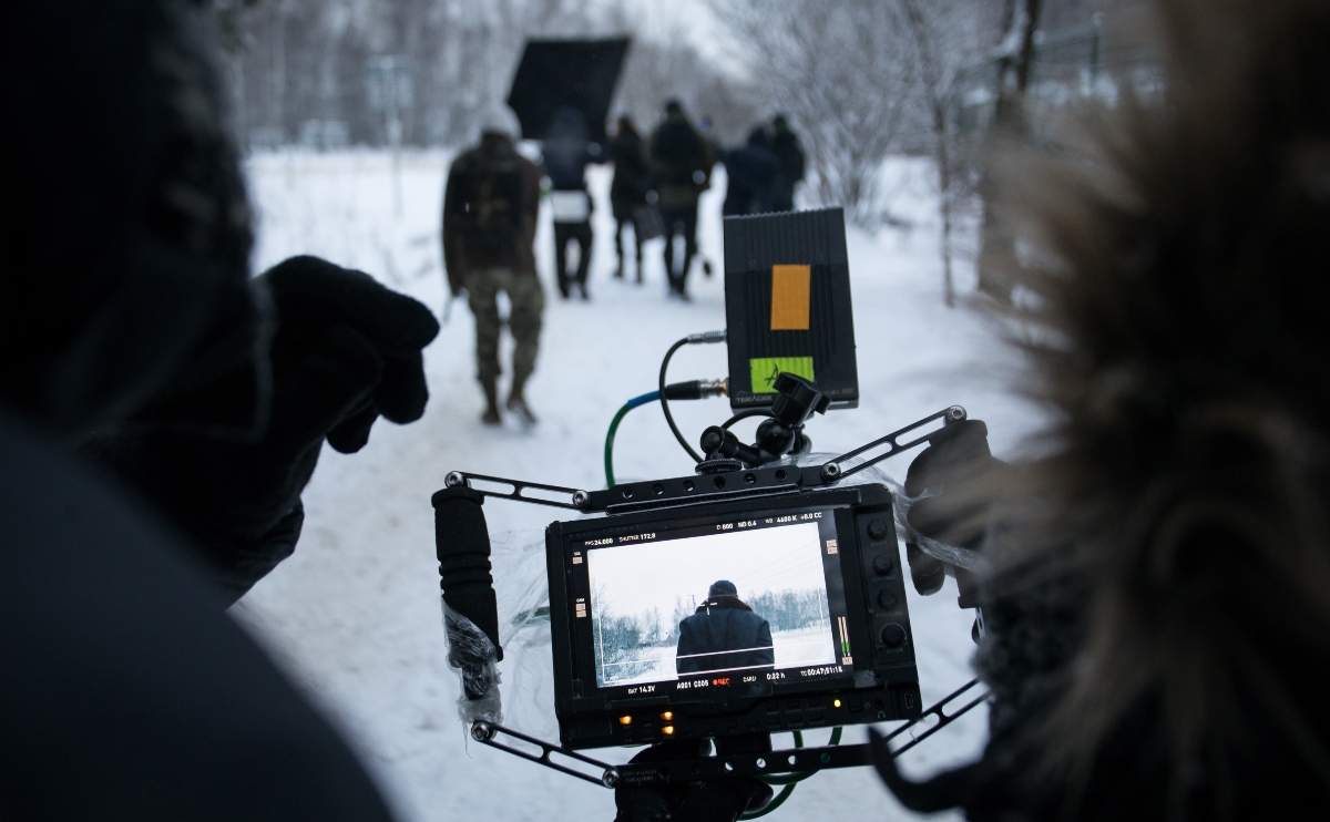 Camera man shooting a feature film during winter