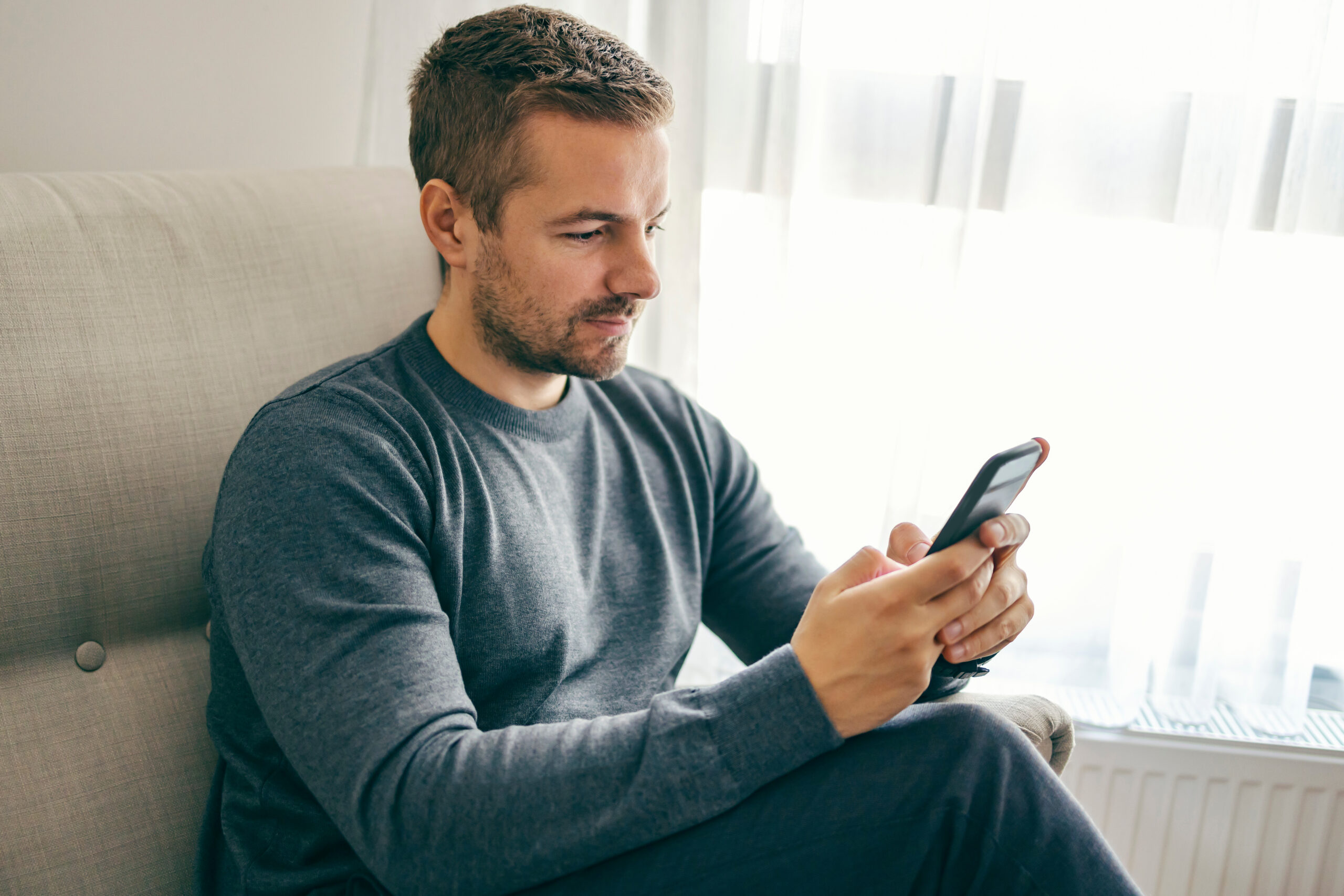 A serious man is on the phone while sitting to find out about how legit onlyshares is.