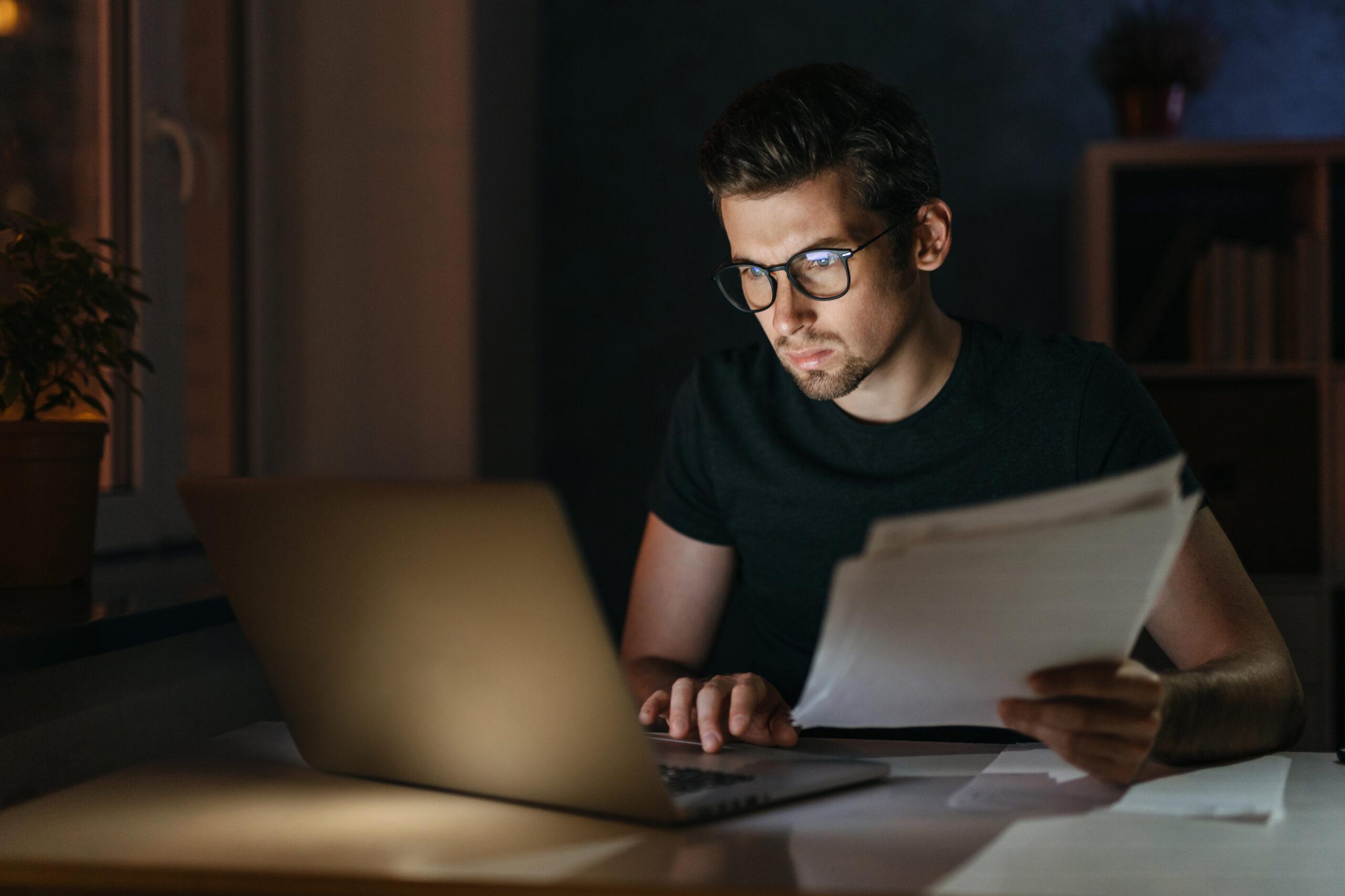 Young businessman working late at night from home