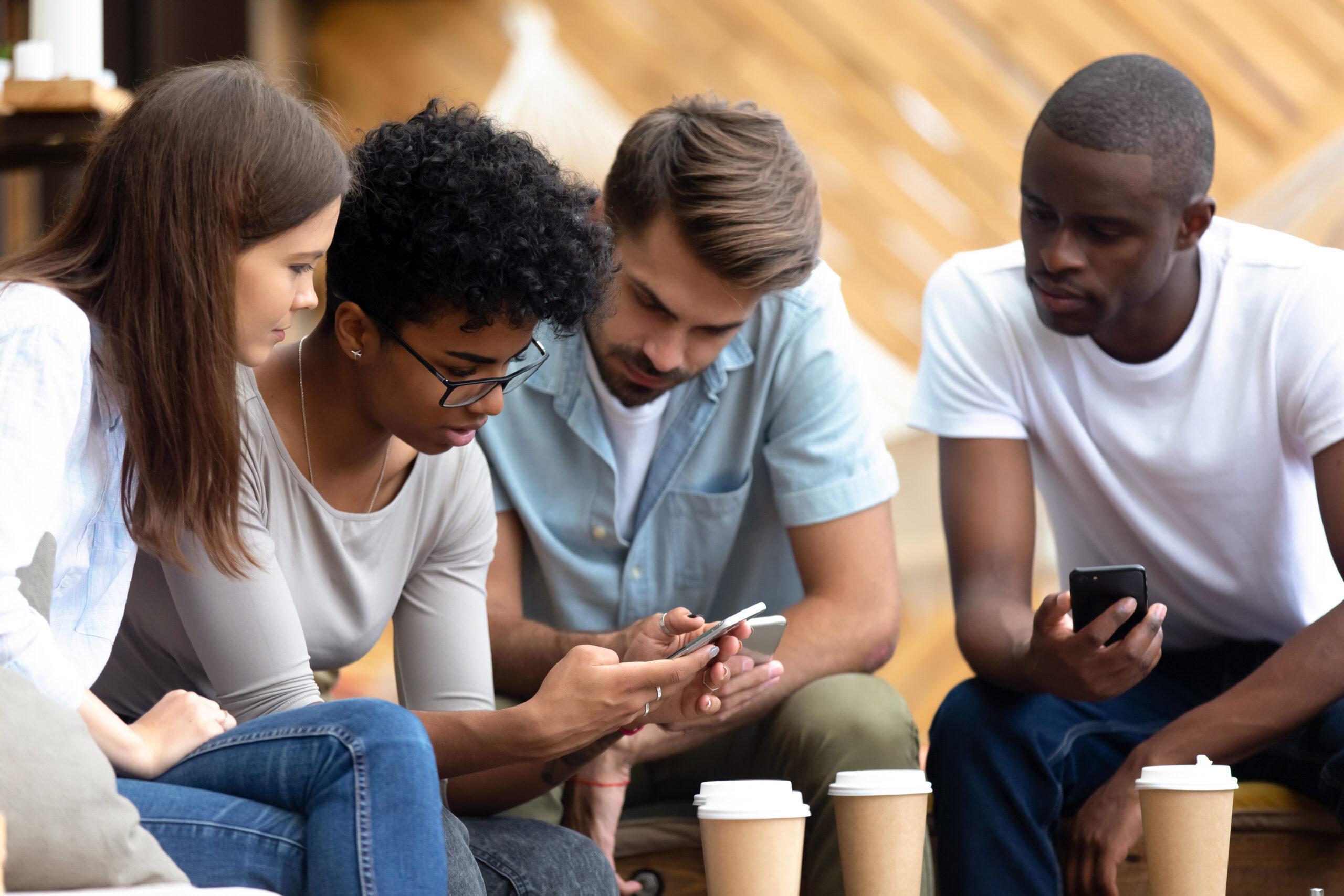 Young people busy using smartphones together