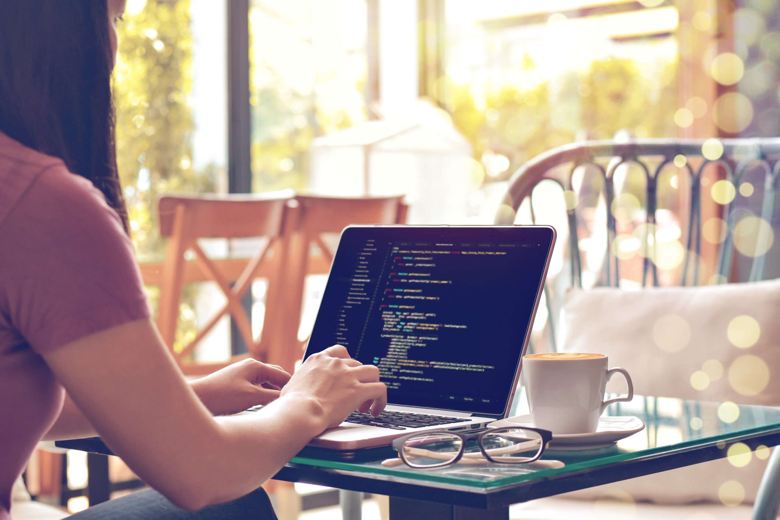 A female programmer typing source codes in a coffee shop