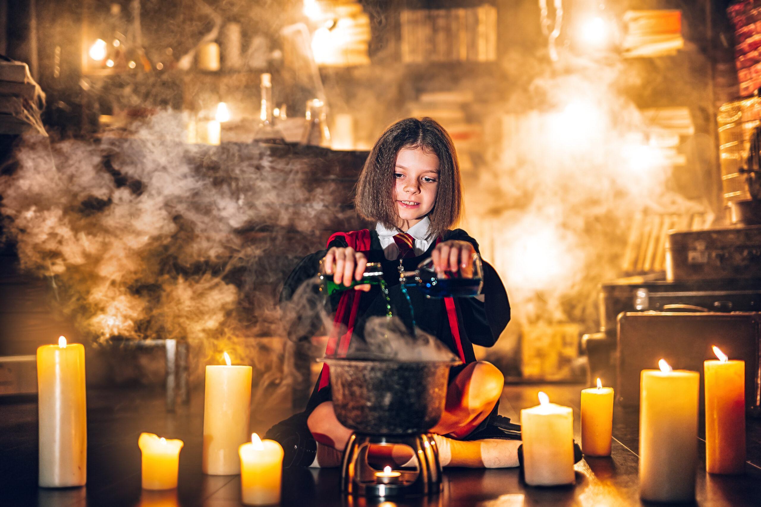 A Harry Potter fan in witch costume pretending to brew a witch's potion in a small cauldron