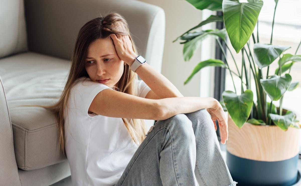 Depressed woman sitting on the floor