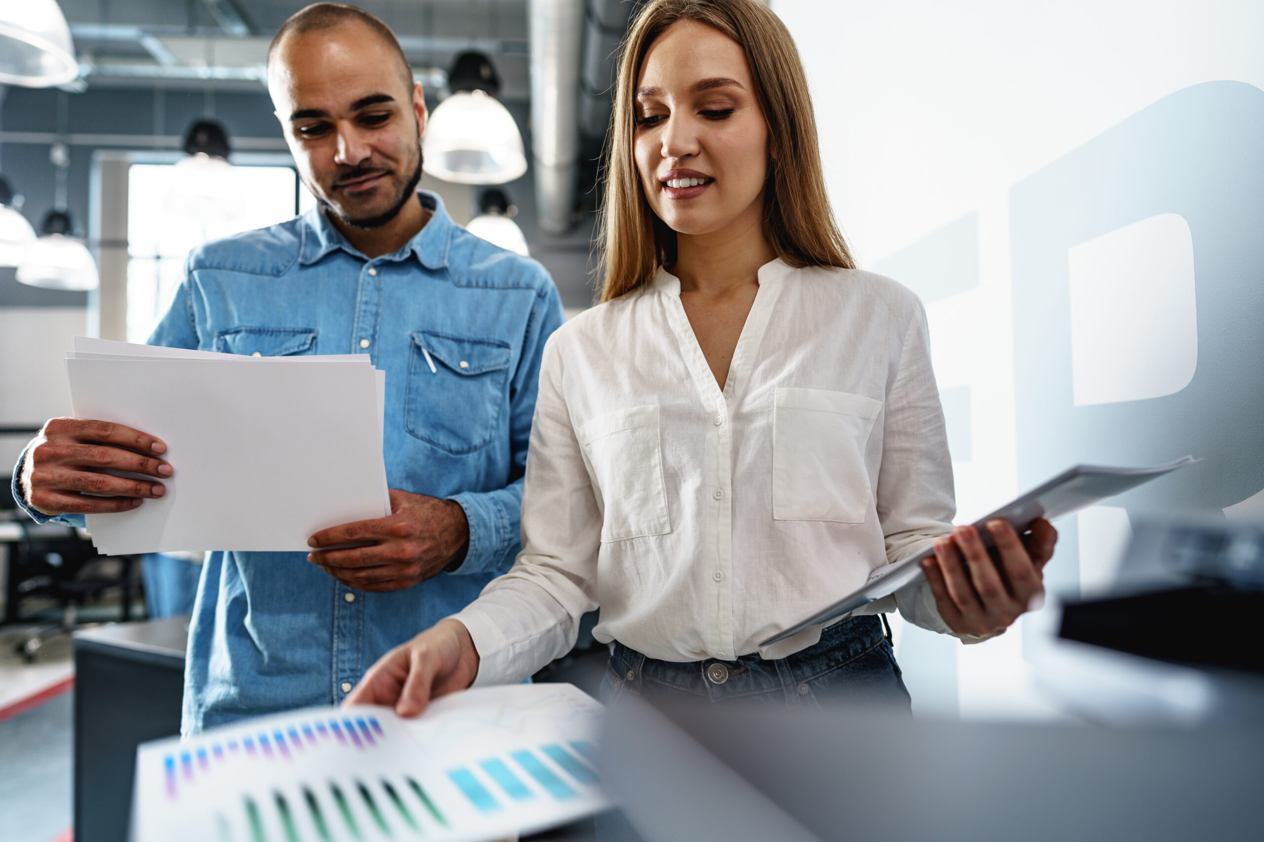 Two employees using new modern printer in office