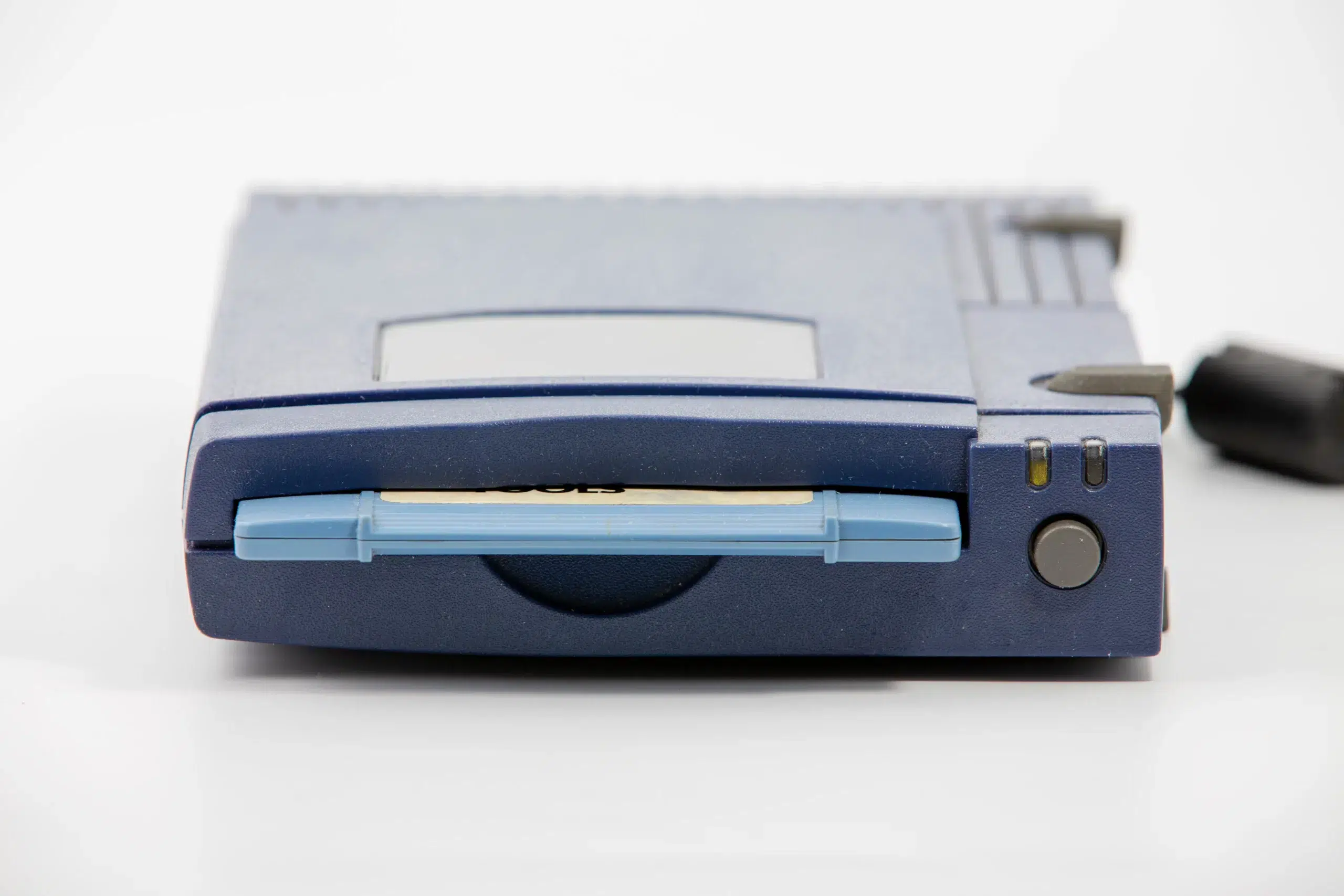 zip drive with blue disk inserted over white background
