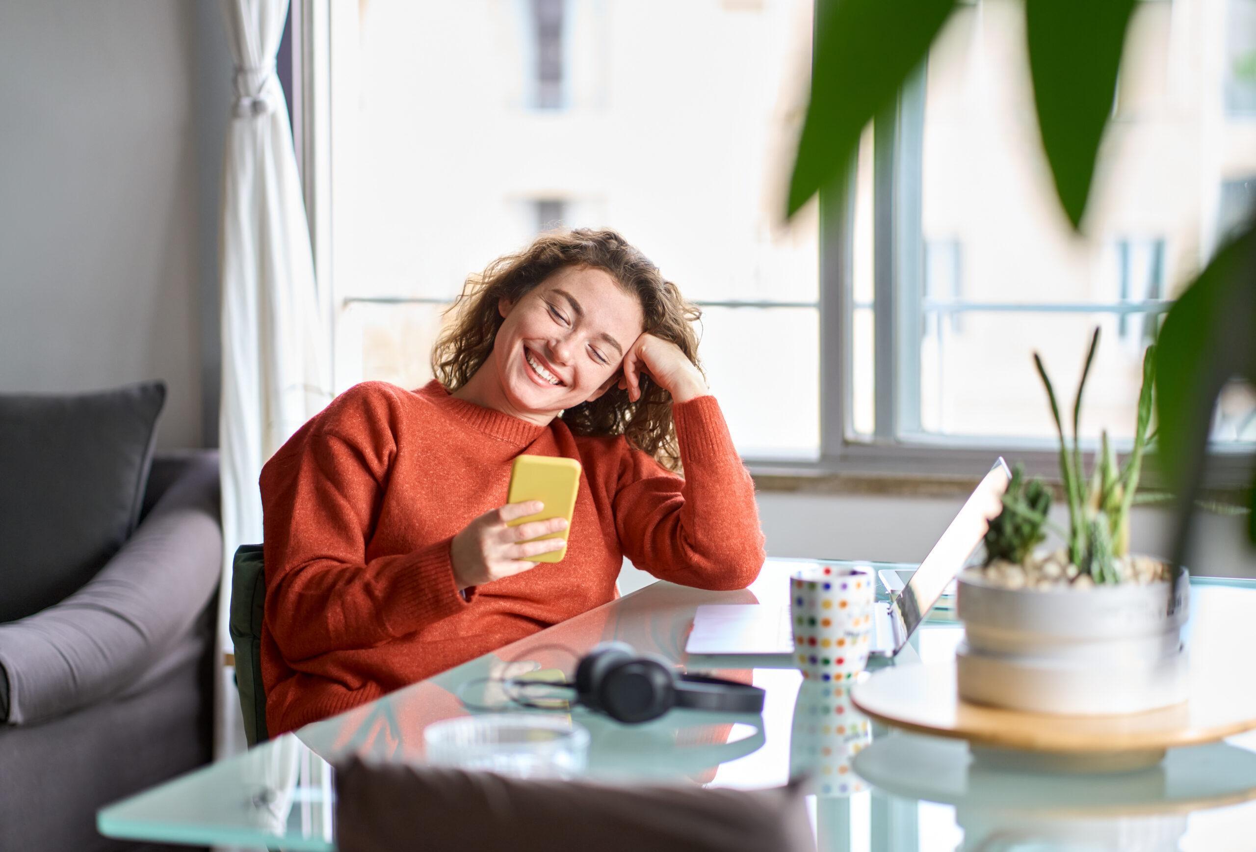 Young woman smiling and using her smart phone