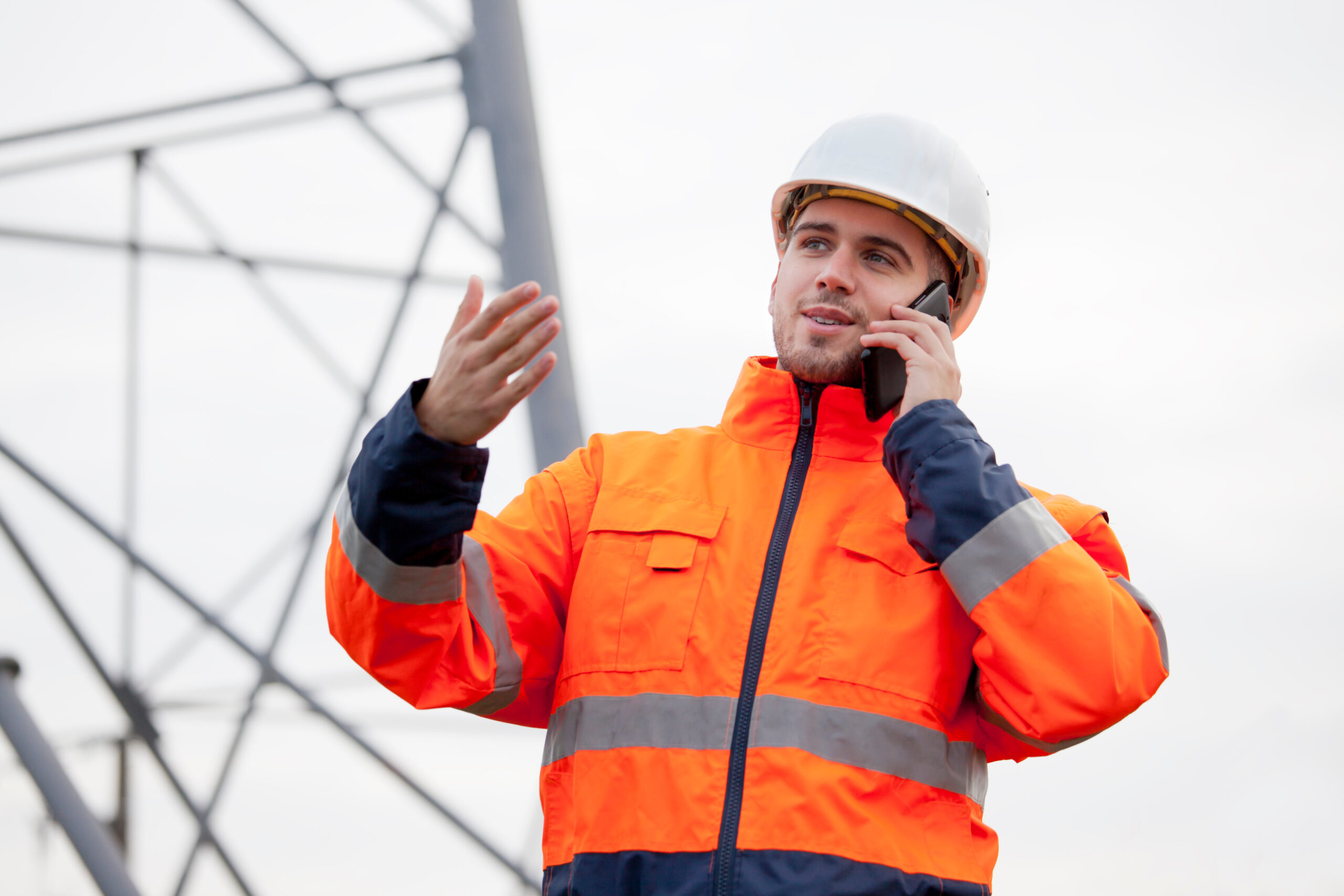 Young smiling engineer talking  on smart phone on an oil platform