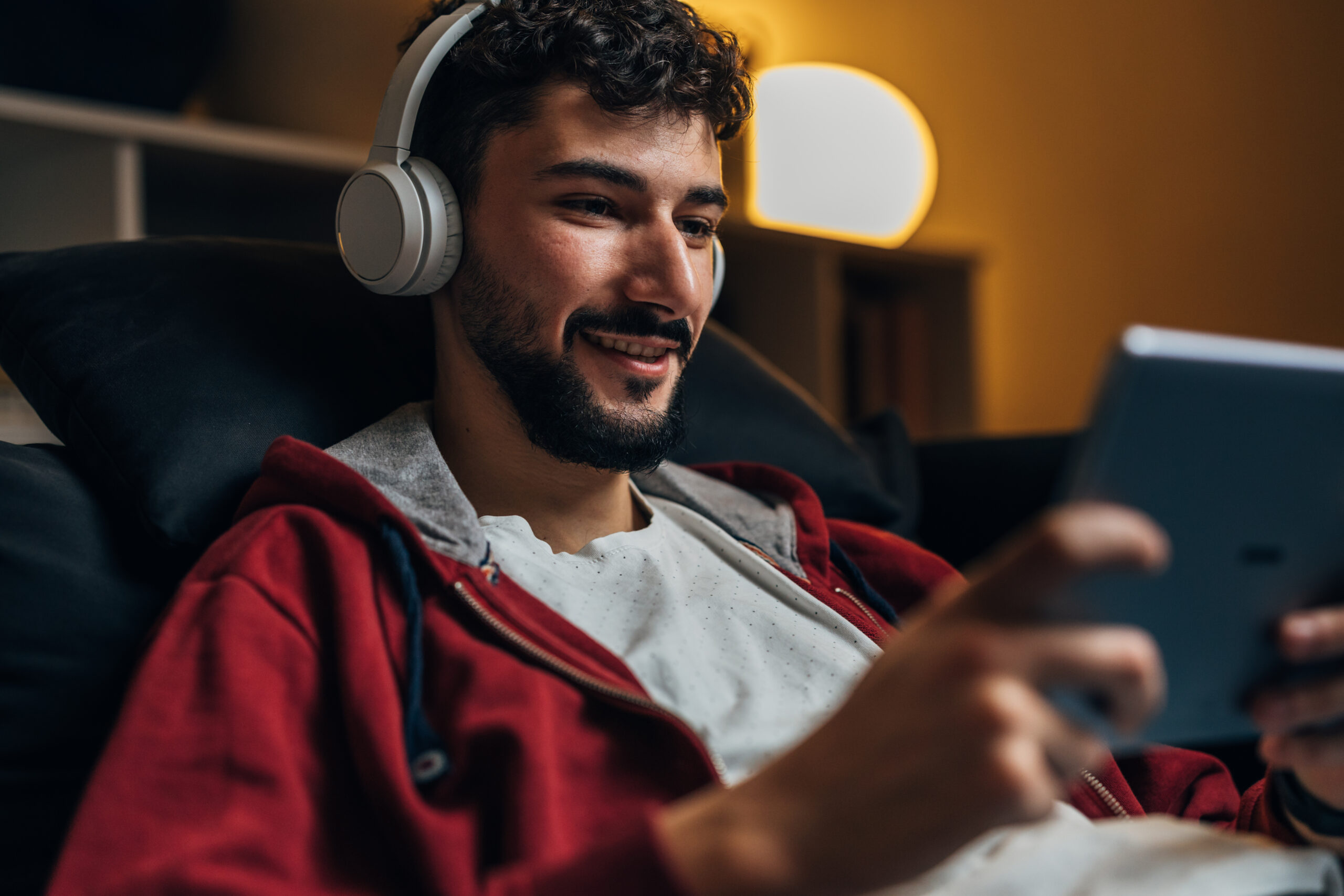 young adult man using digital tablet smiling
