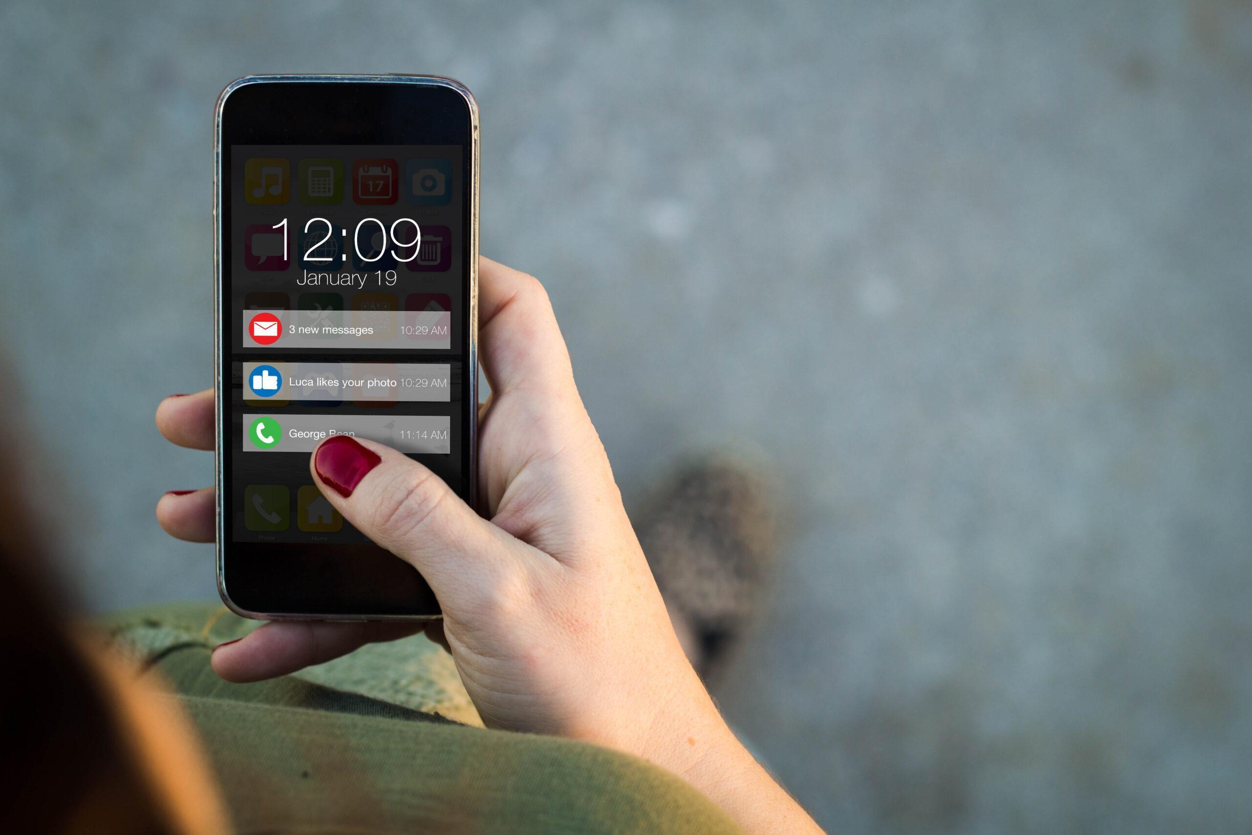 Top view of woman walking in the street using her mobile phone with notifications on screen