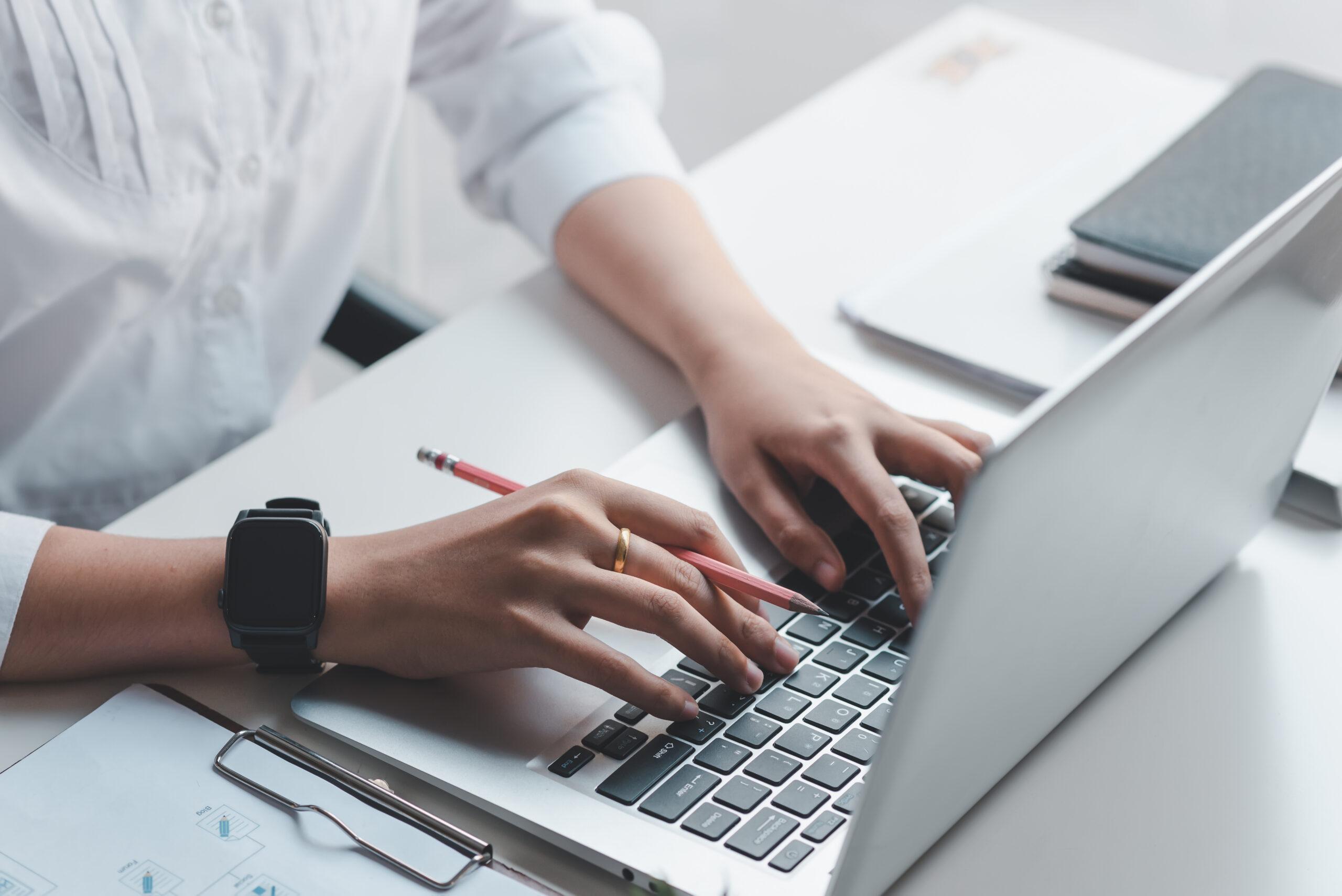 close up of female hands typing on computer