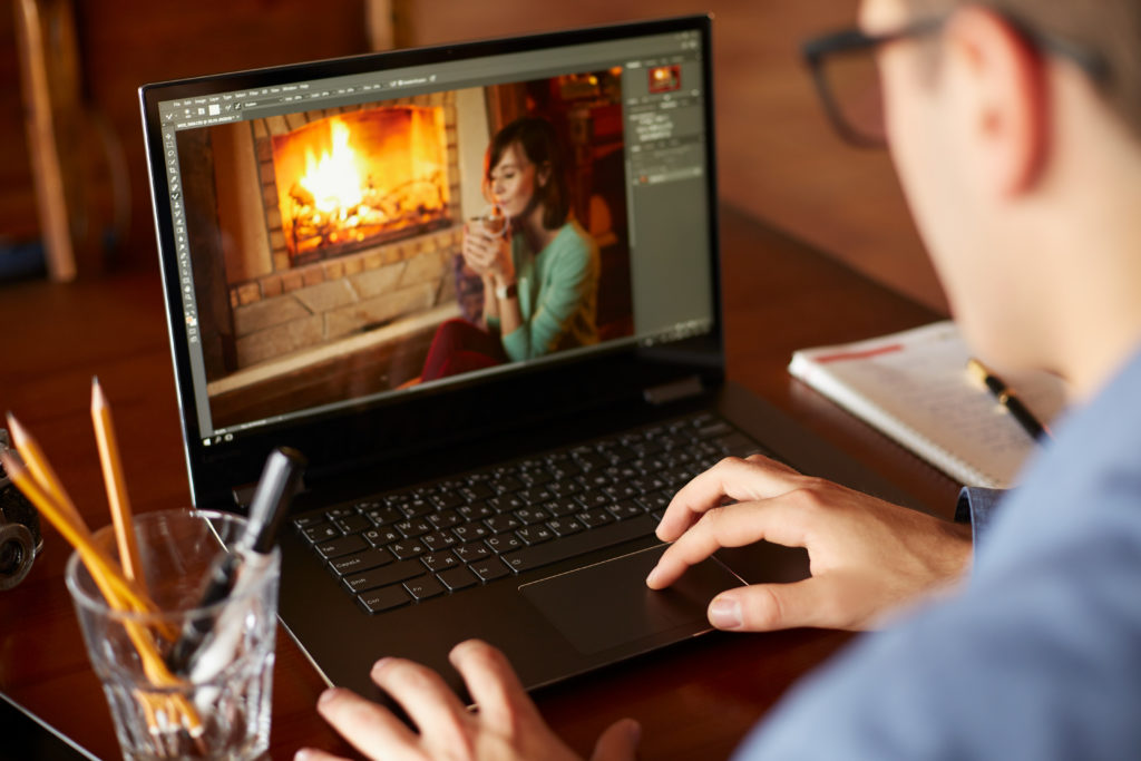 Man working on a laptop with photo editing software. 