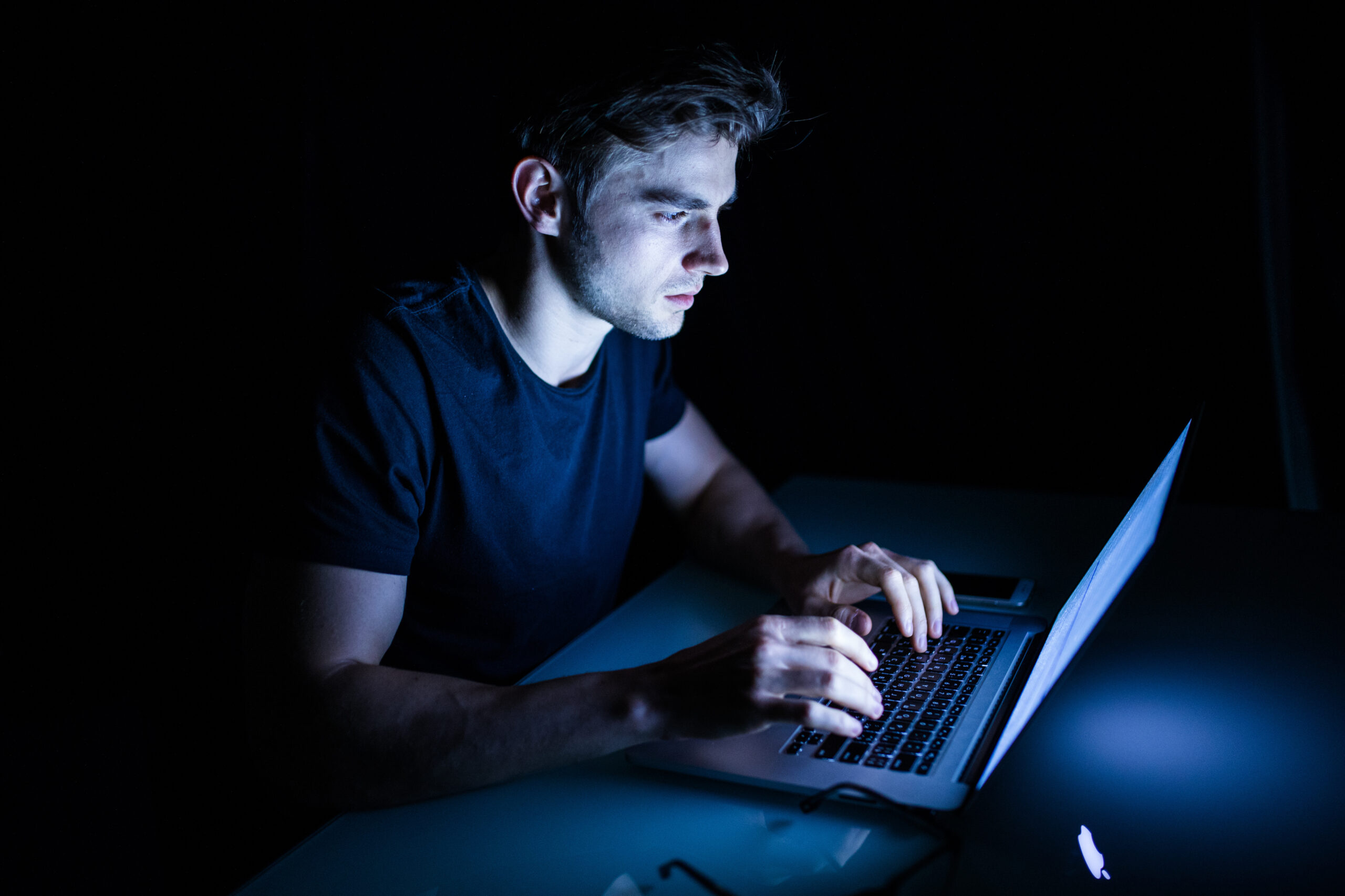 Young man watching content on his laptop at night