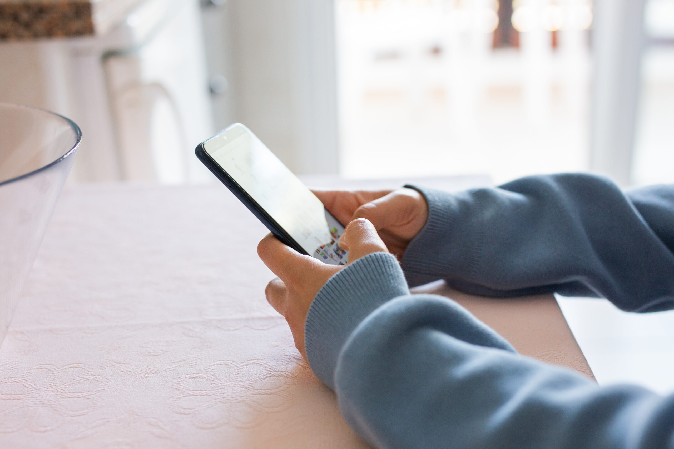 hands of a young woman sending a message on her phone