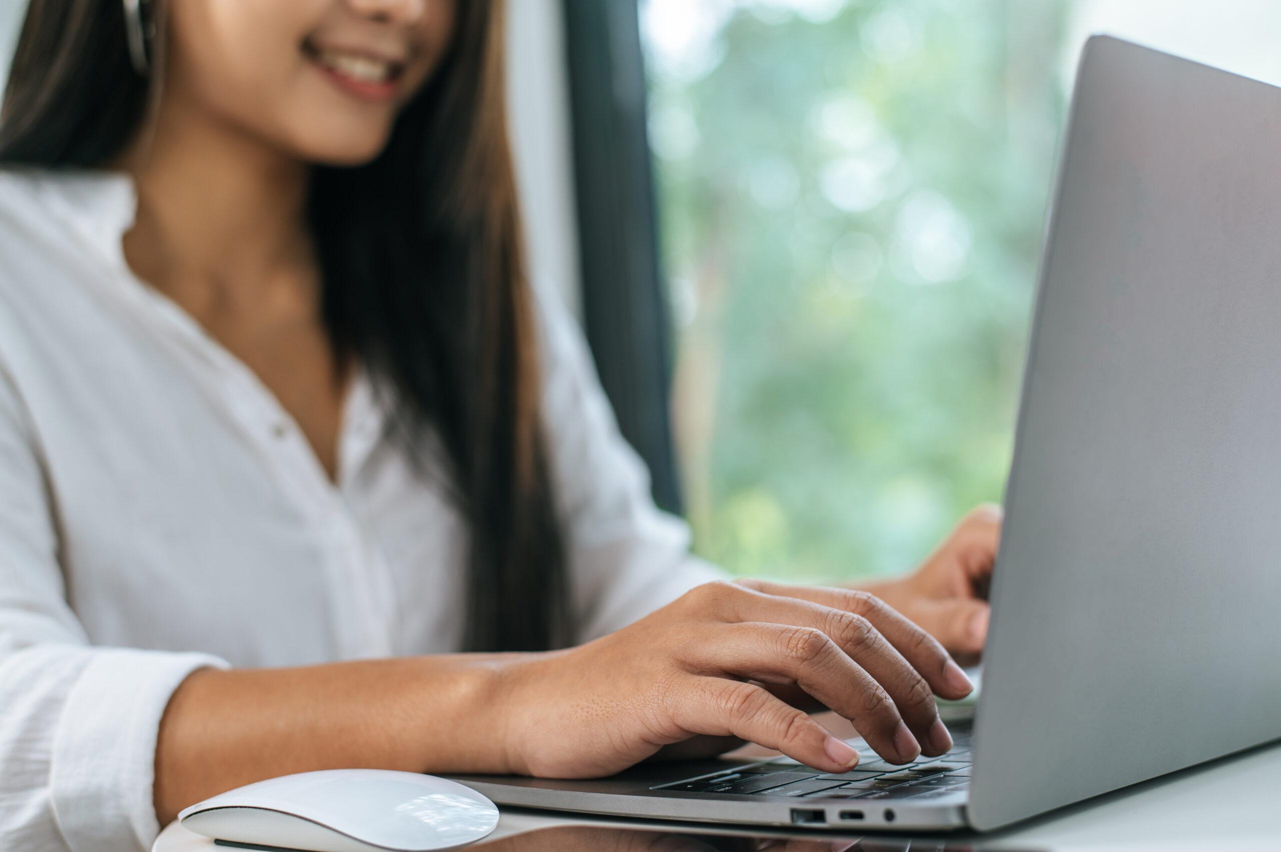 Young woman working on laptop computer in coffee shop