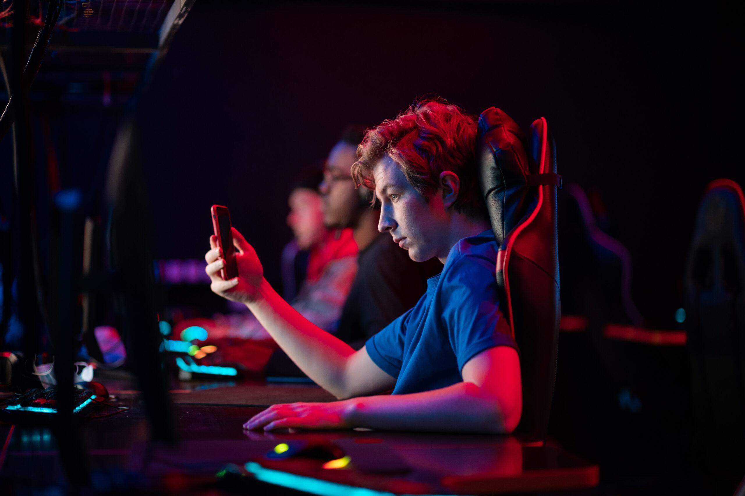 A young esports player playing a game on his mobile phone