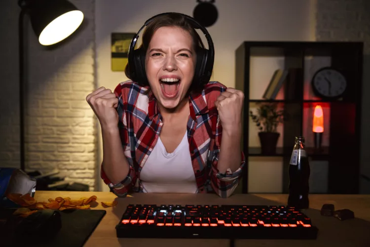 Excited girl wearing headset playing online games