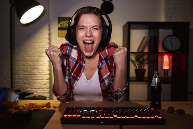 Excited girl wearing headset playing online games
