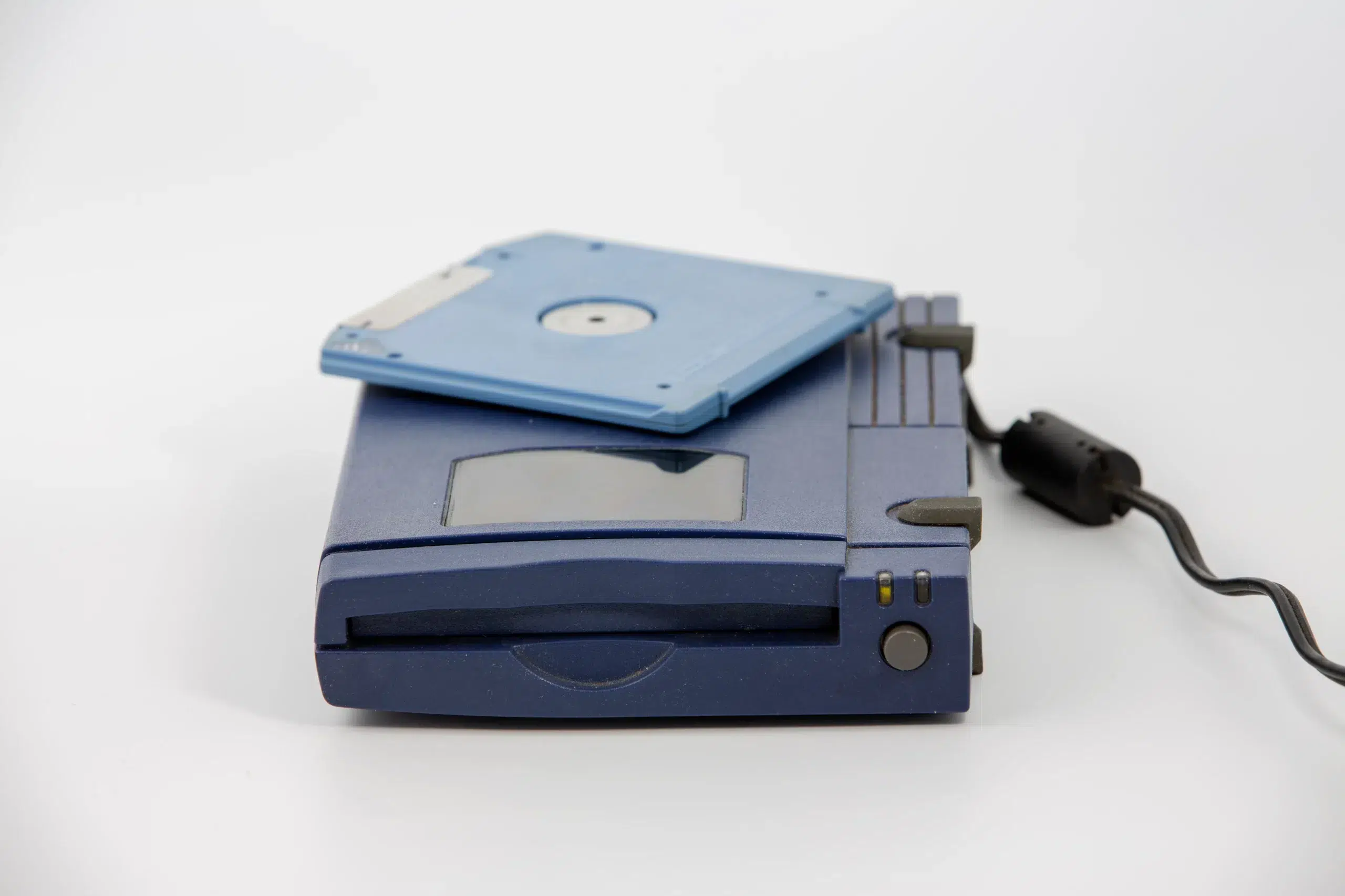zip drive with blue disk inserted over white background