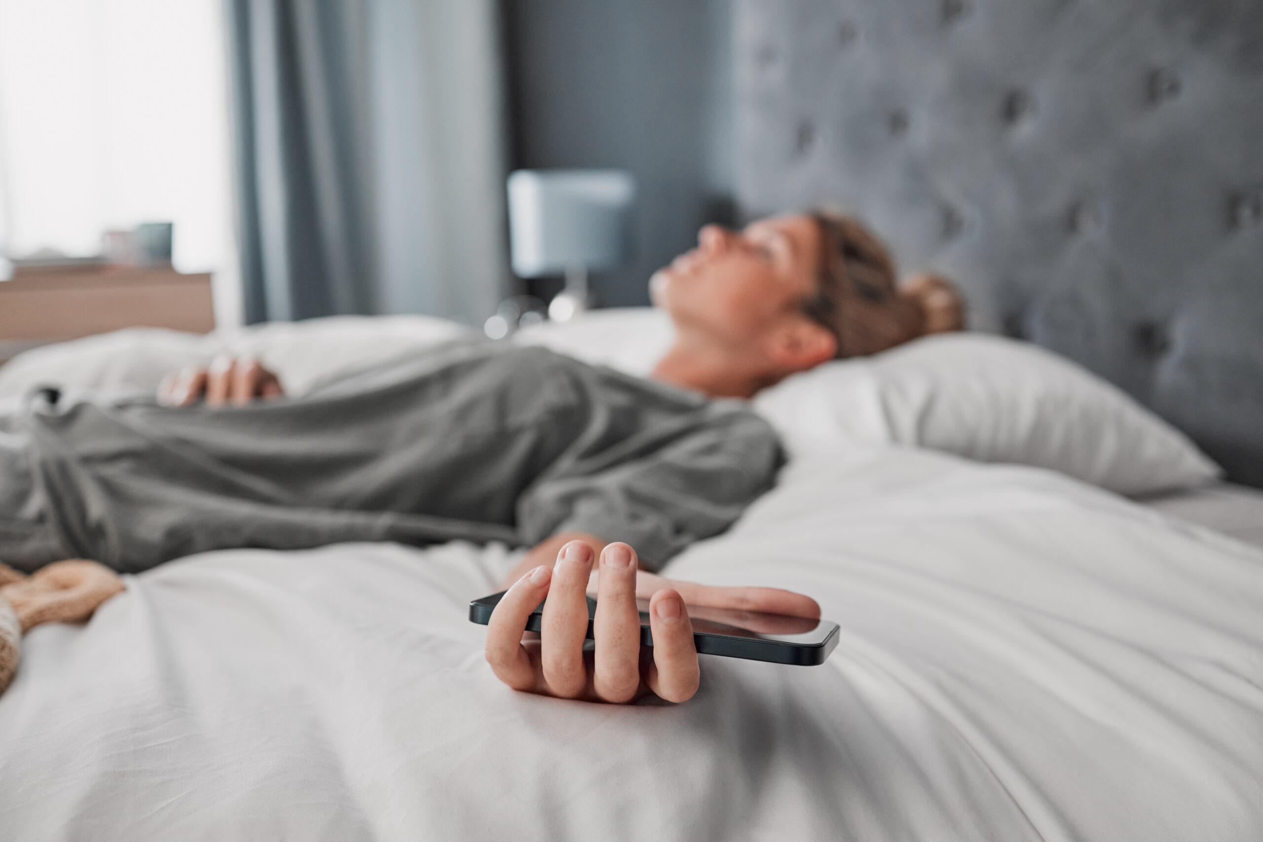 Woman lying on the bed, phone in hand, not listening or messaging anymore