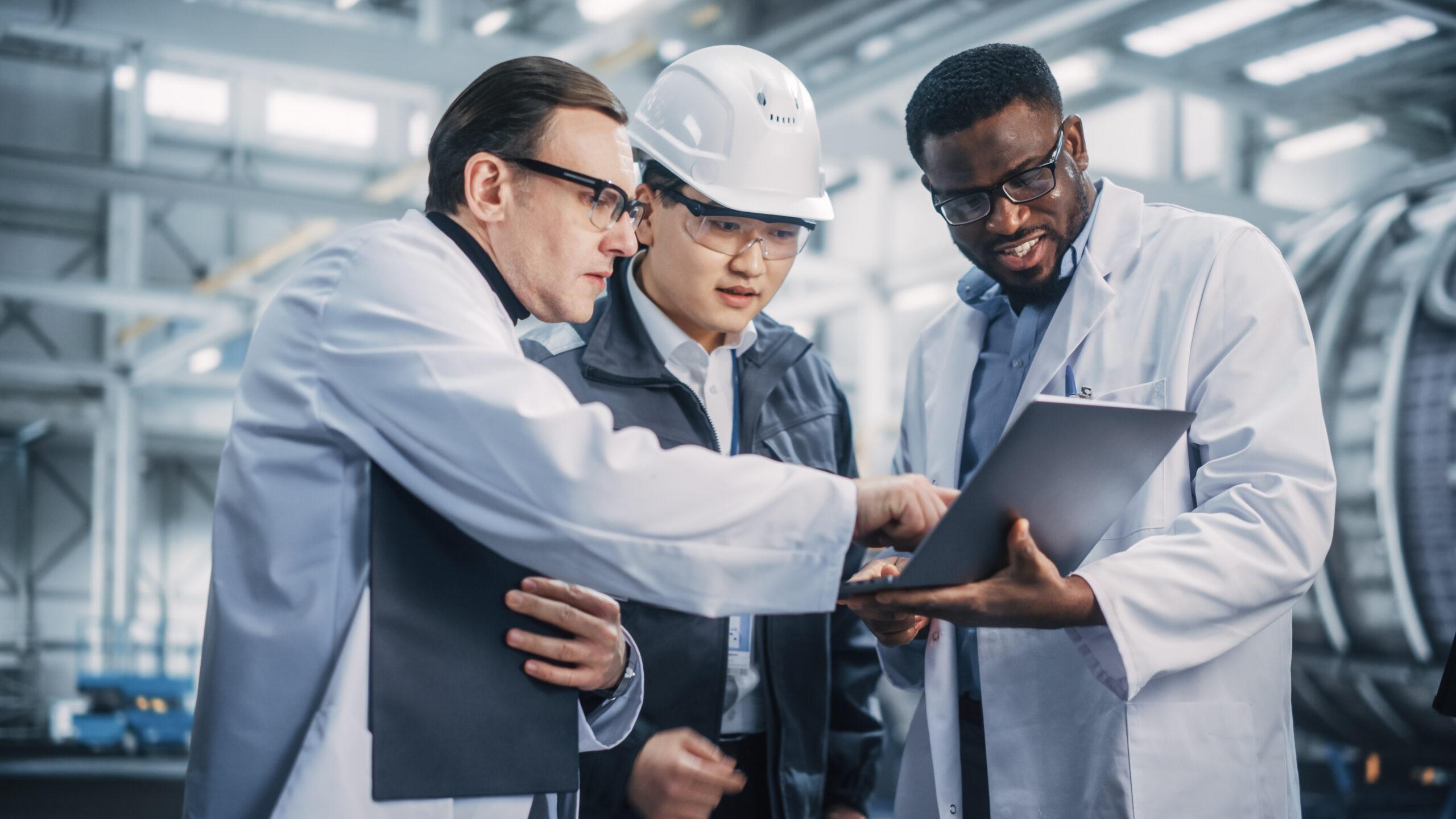 Team of engineers and technician analyzing outcome of tests on laptop