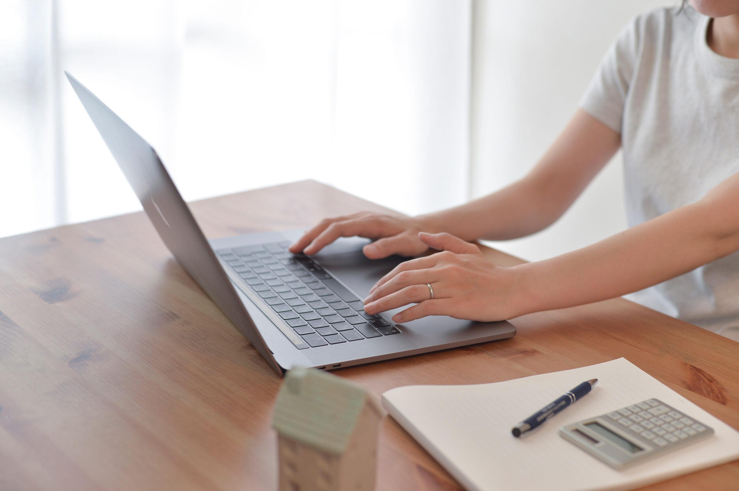 Woman (only hands visible) working and typing on her laptop