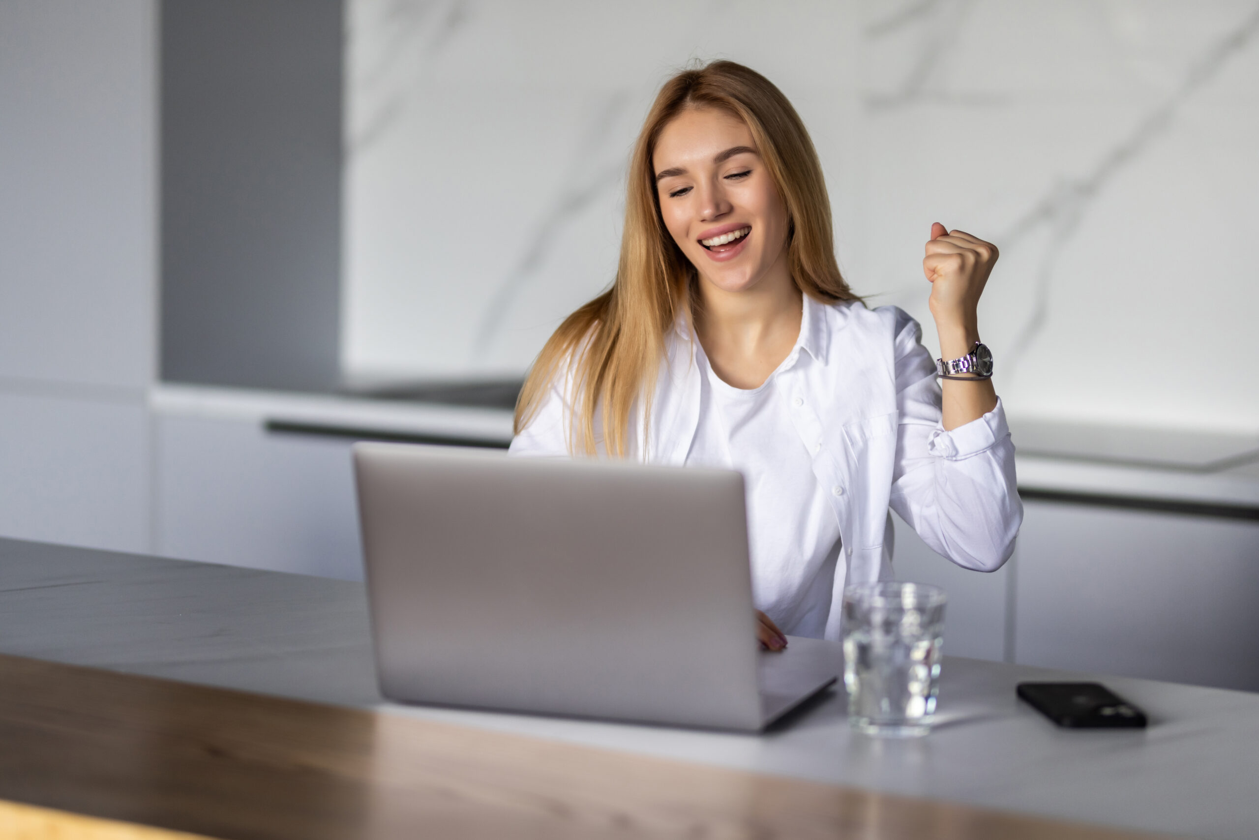 smiling woman with laptop looking excited about something