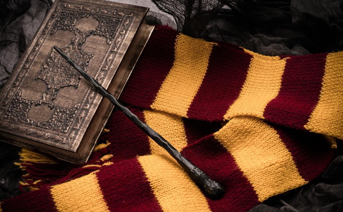 Scarf, magic wand, book of spells on grey background