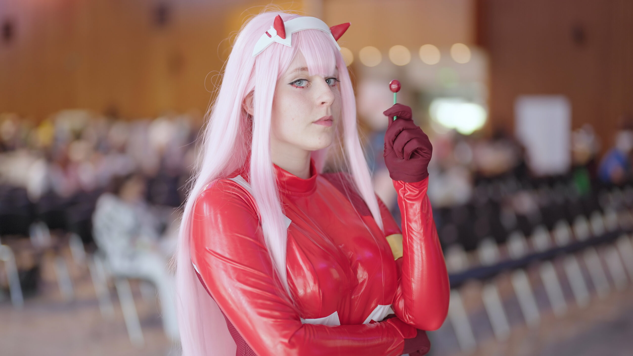 Zero Two anime cosplay girl in suit holding lollipop 