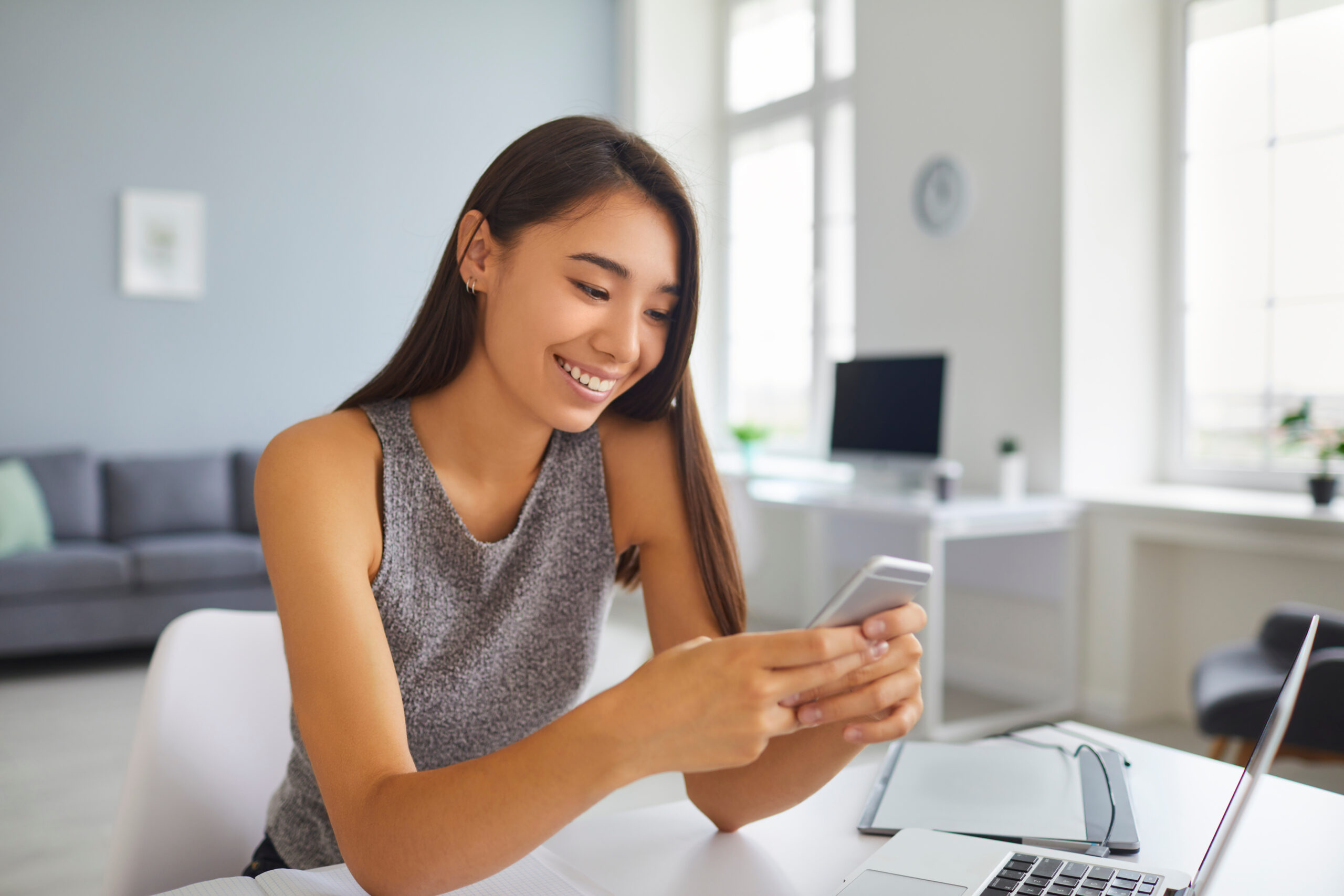 cheerful female blogger scrolling through social media news feed on mobile phone