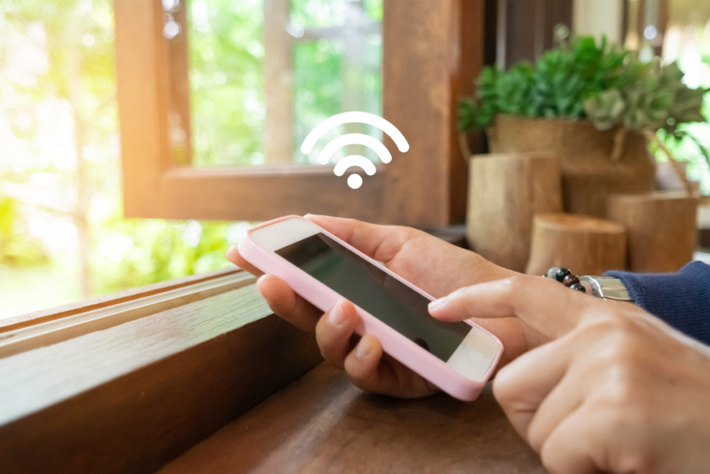 Woman using smartphone with wifi in a cafe.