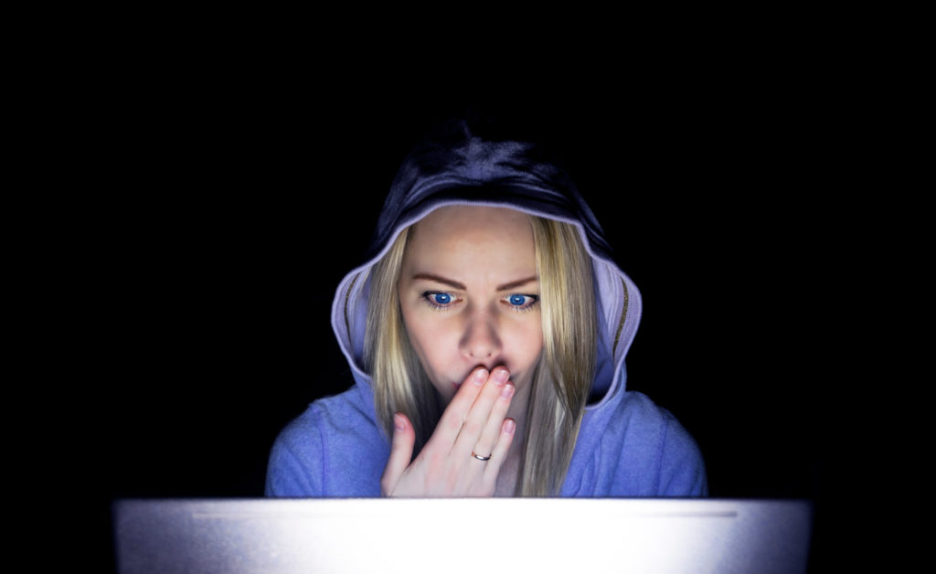 Young beautiful woman appears to be shocked face looking at her laptop.