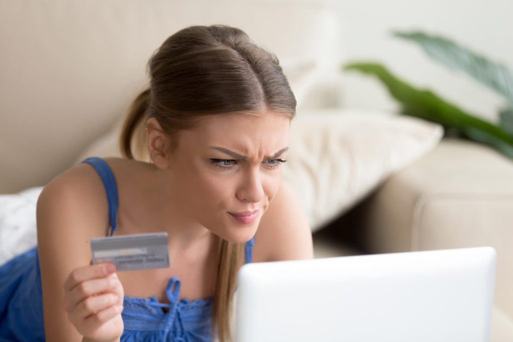 Confused woman having problem with credit card making online pay