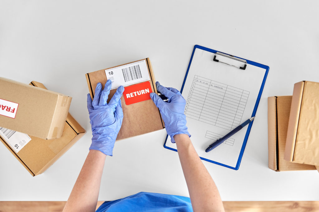 Hands in gloves with returned parcel box