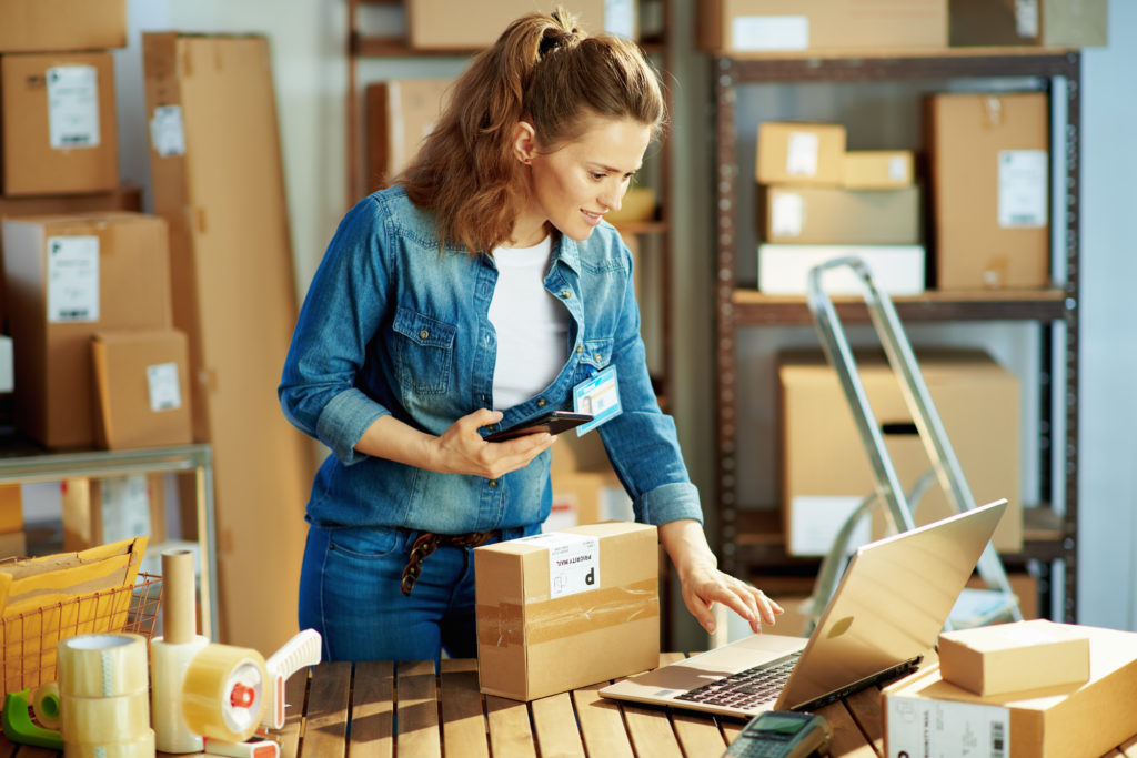 Woman preparing an order packaging it for delivery.