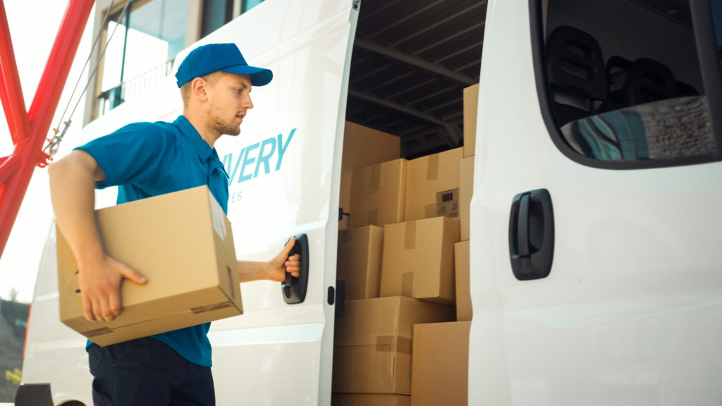 Courier takes out package from delivery van.