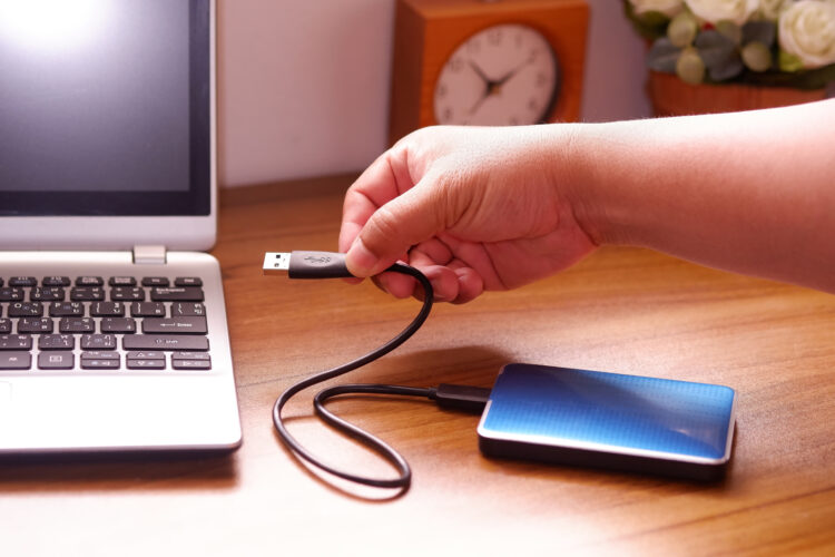 Man's hand was connecting an external portable hard disk usb 3.0