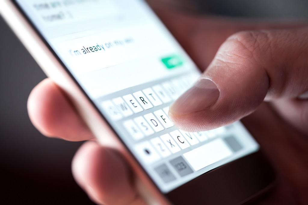 Man sending a text message with smartphone.