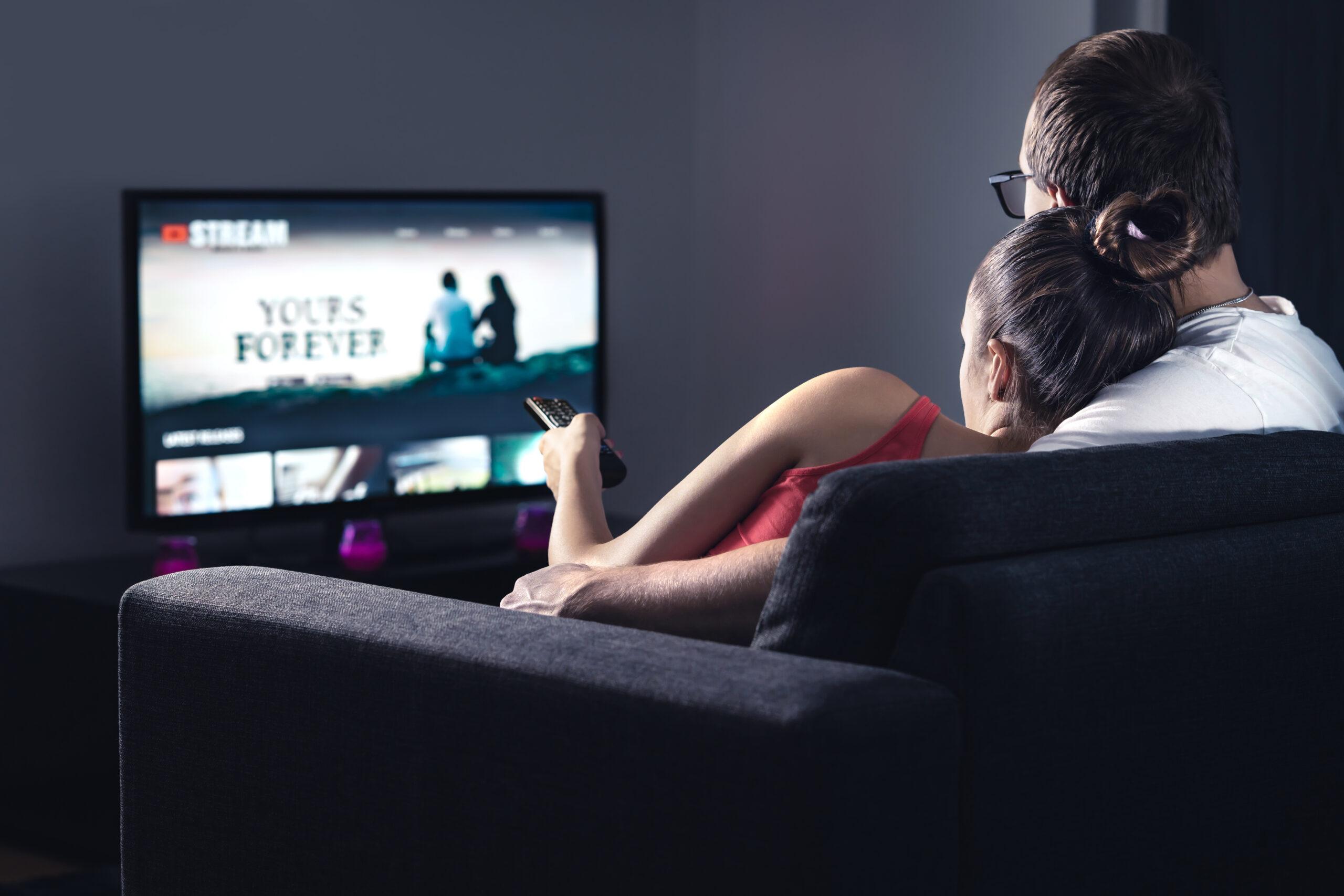 Movie stream service on smart tv. Couple watching series online.