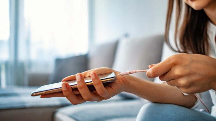 Woman hands plugging a charger in a smart phone. 