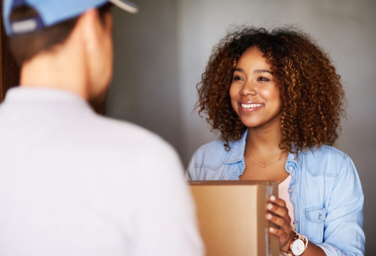 smiling woman receiving her package from the delivery man.