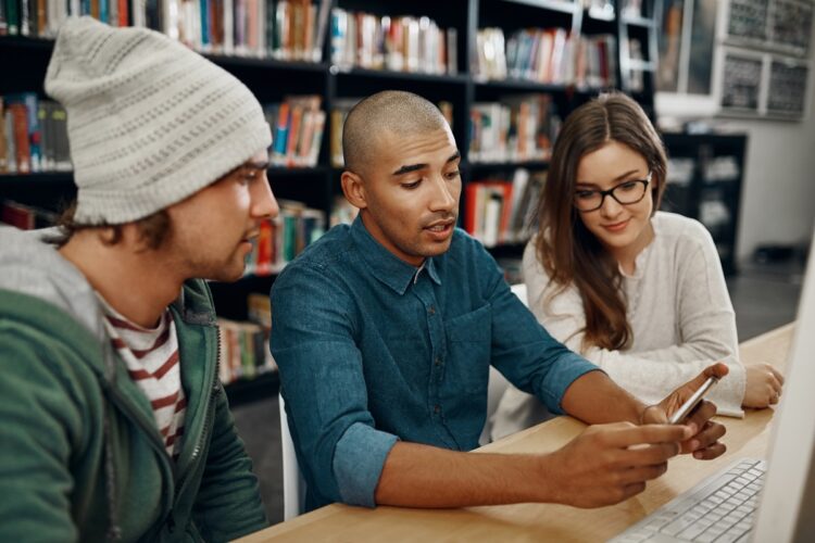 university students looking at a video together in the library