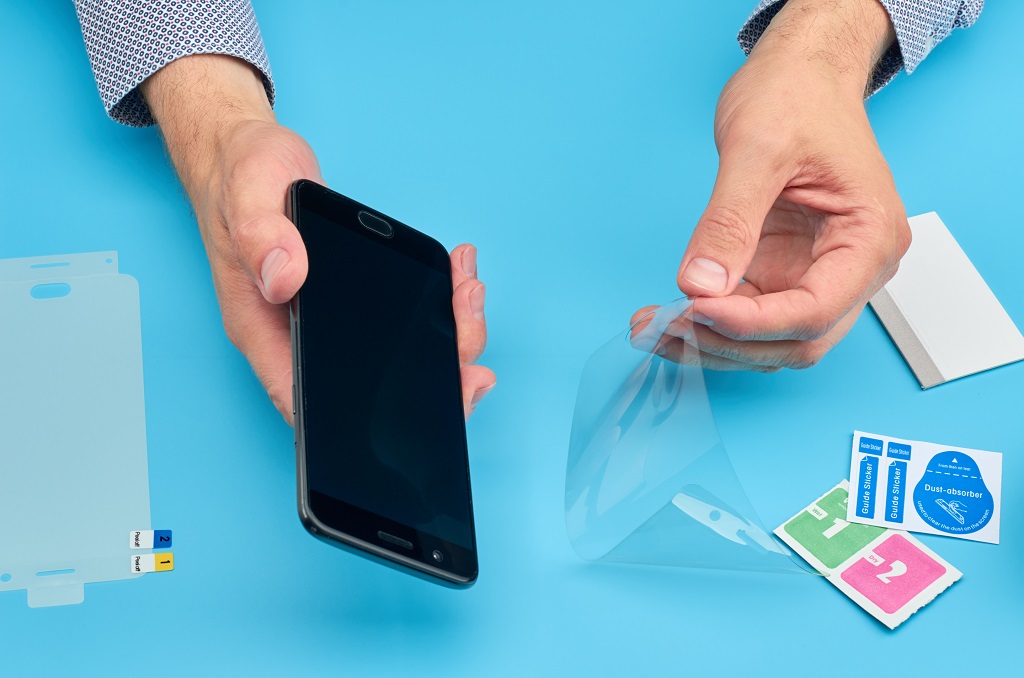 Man replacing the broken tempered glass screen protector for smartphone.