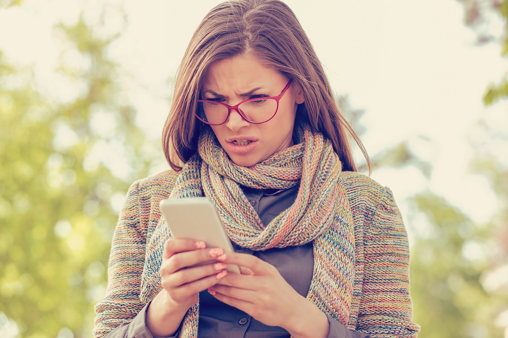 Woman looking annoyed at the phone.