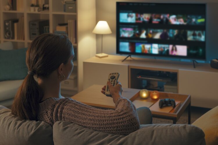 Woman watching TV at home and relaxing