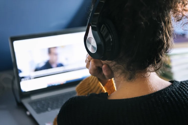 woman with headphones watching a movie on laptop