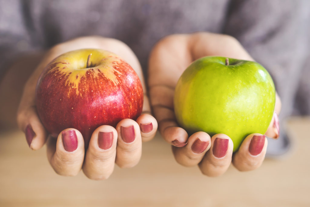 Woman hand holding red and green apple fruit for diet.