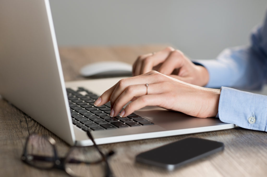 Female hands typing on laptop