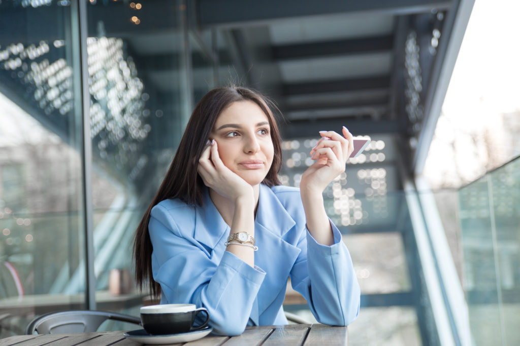 Annoyed woman holding phone to side rejecting call.