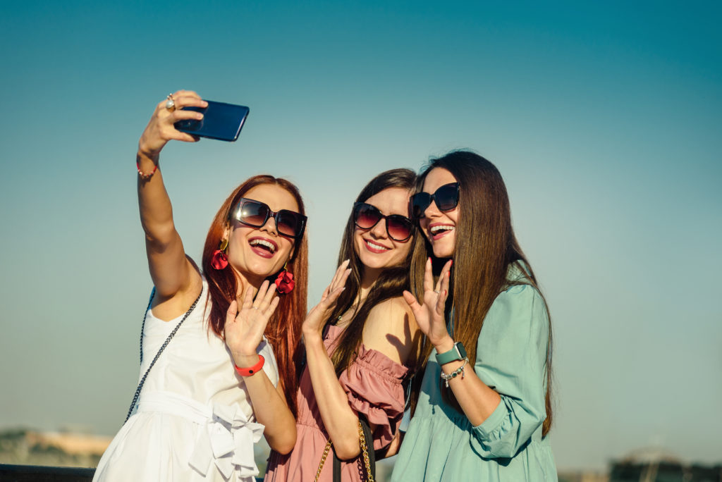 Beautiful young girls taking a selfie outdoor.