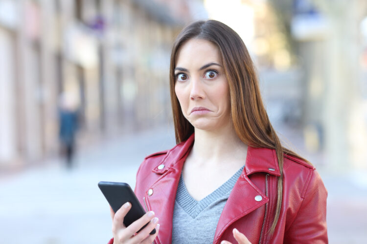 Perplexed woman using phone.